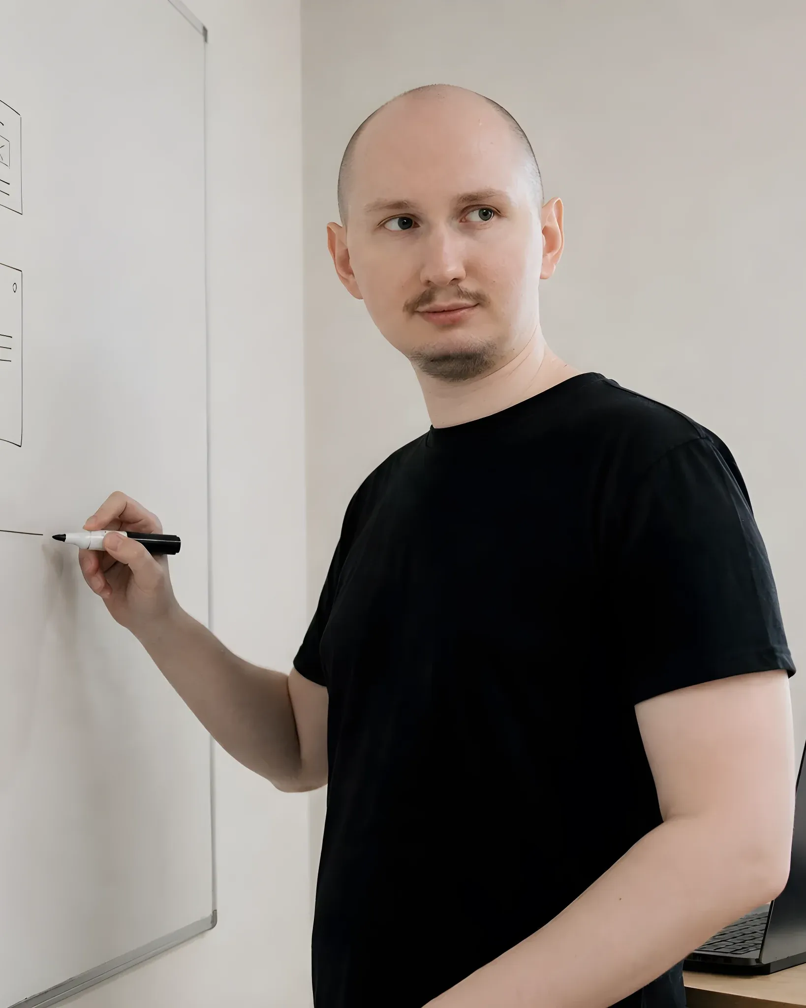 Me sketching wireframes and a sitemap on a whiteboard