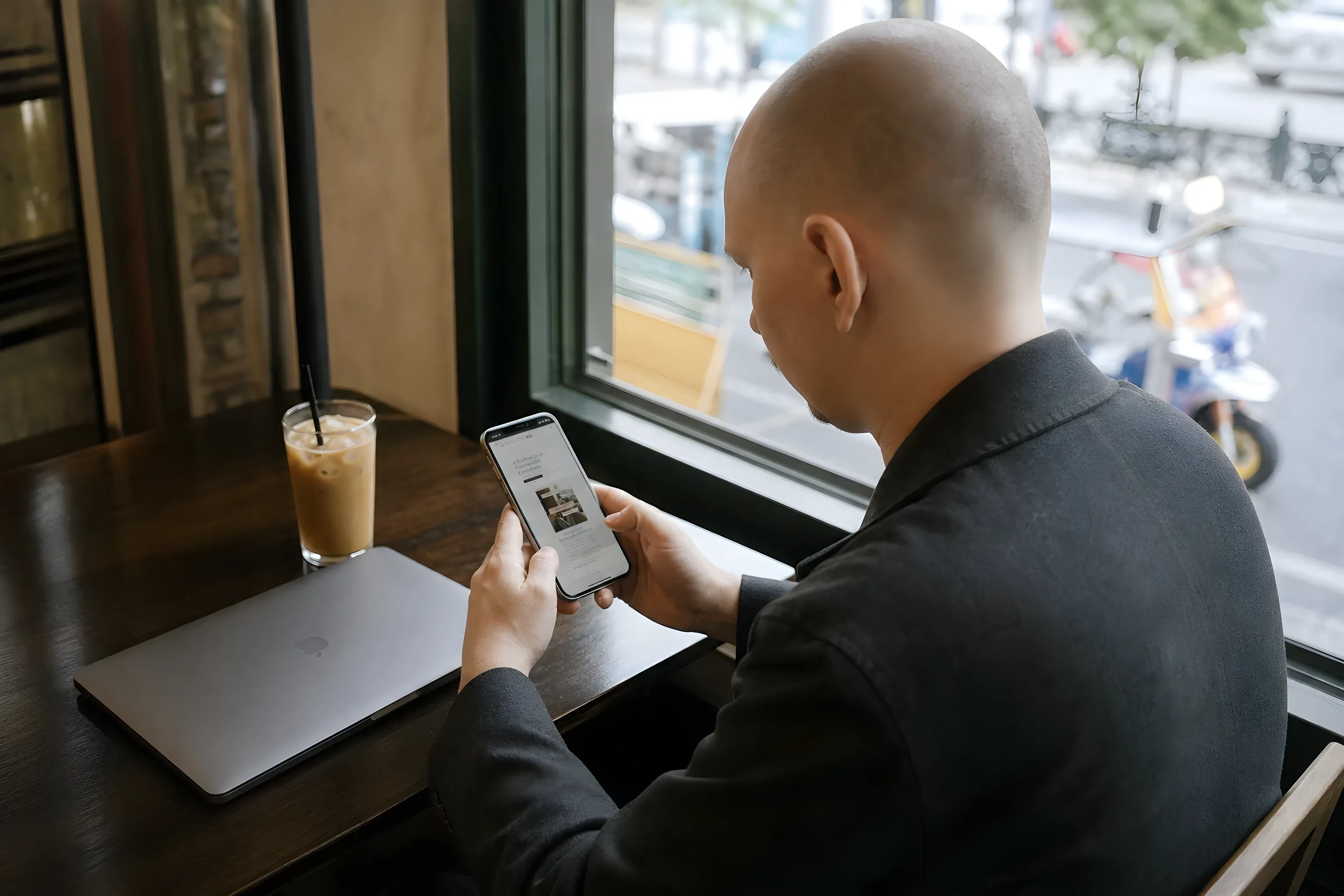 Ich prüfe die Website von All That’s Stylist Service auf meinem Smartphone in einem Café in Bangkok