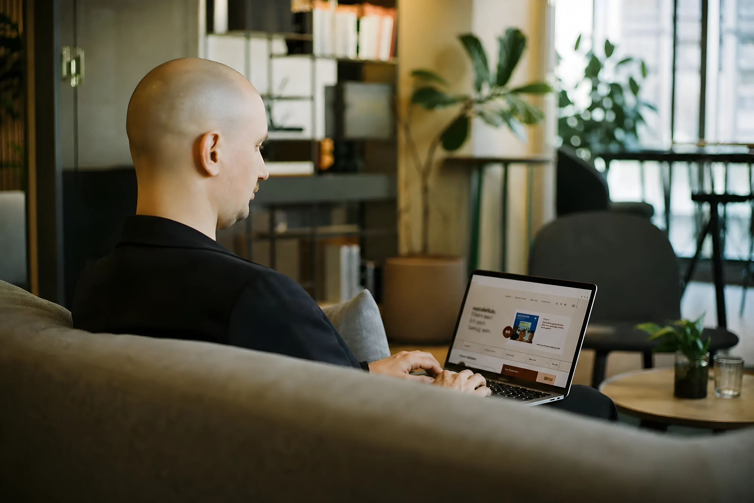 Ich auf einem Coworking-Sofa, die mal-ehrlich-Seite offen auf meinem MacBook